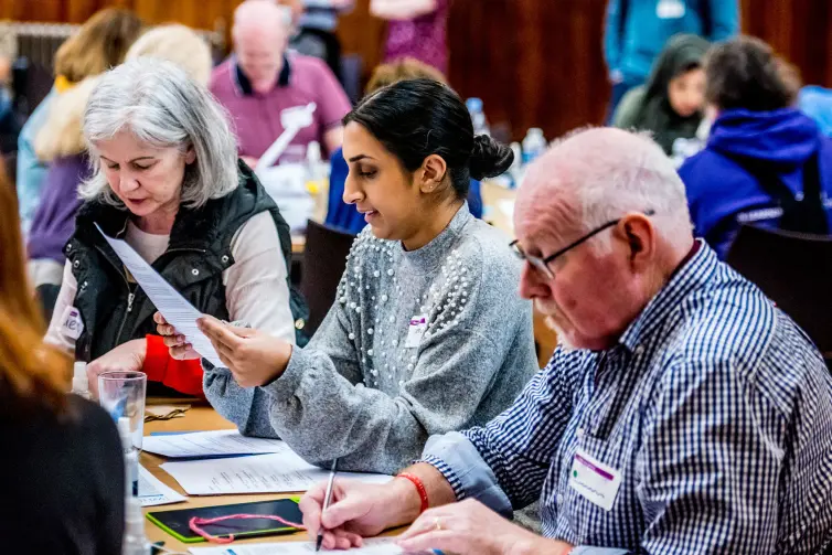 A group of people sitting at a table looking at papers.