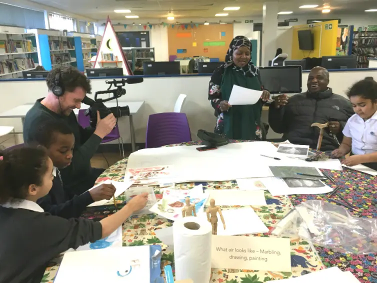 Young people creating art around a table.