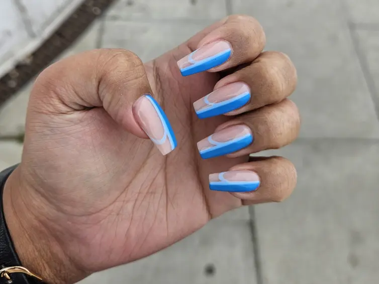 A photo of someone's hand, showing their nails just after being painted.