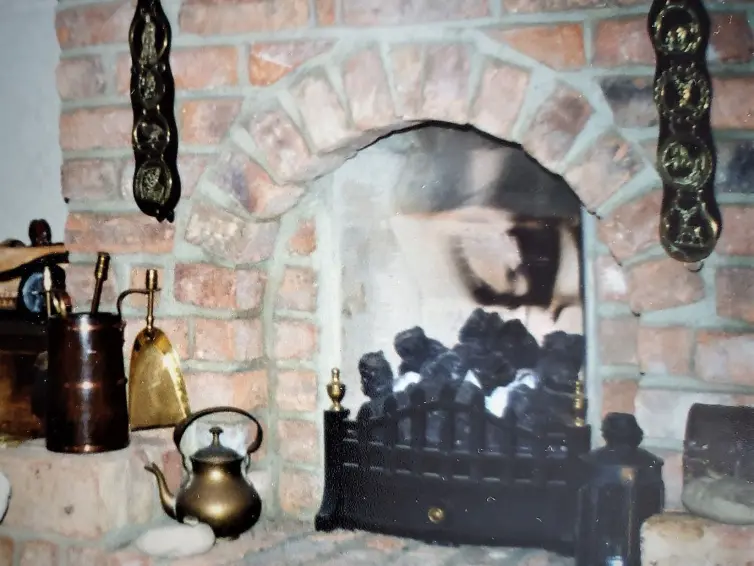 Brick layered fireplace with decorative objects around.