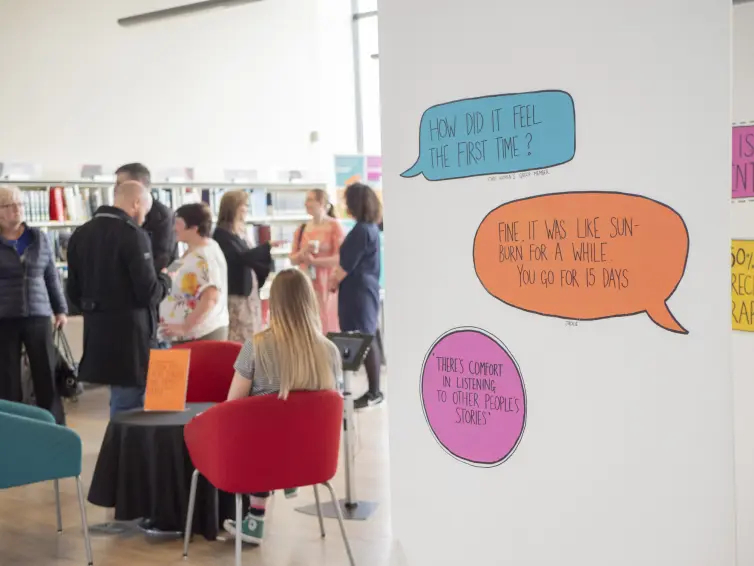 People talking to each other during an art exhibition in a library.