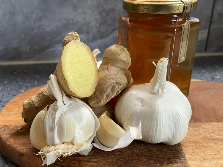 Two heads of garlic, ginger and honey.