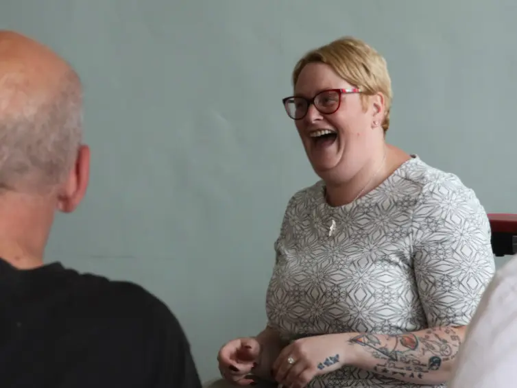 Woman laughing in front of two men.