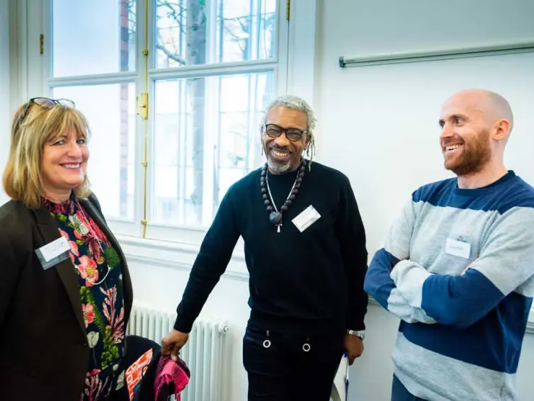 Three people smiling at camera.