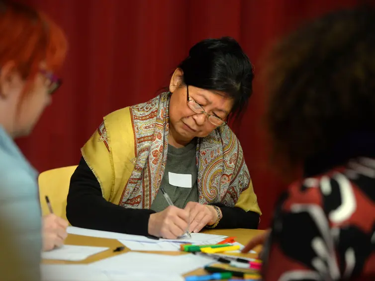 People sat at a table crafting.