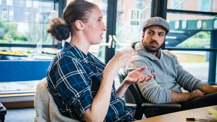 Two people sitting at a table talking.