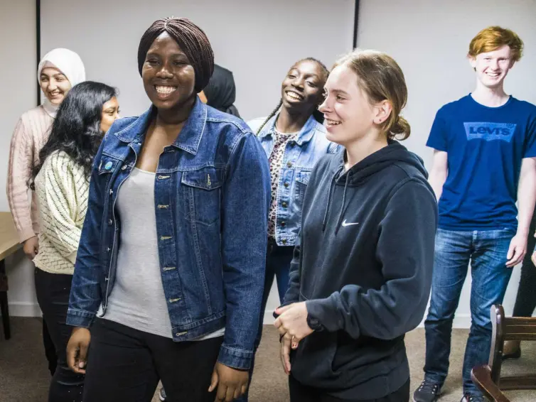 A group of young people standing and smiling.