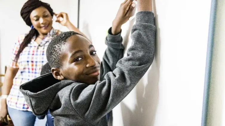 Two people, one young person leaning against board.