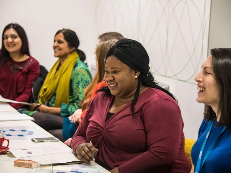 A group of people laughing around a table.