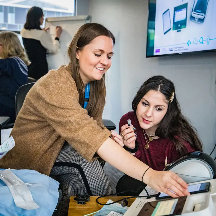 Two women smiling sat at a desk.